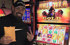 Jackpot winner Joseph S. standing by a slot machine