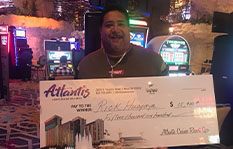 Jackpot Winner Rick H. holding a check