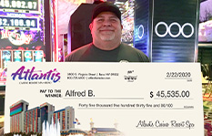 Jackpot Winner Alfred B. holding a check